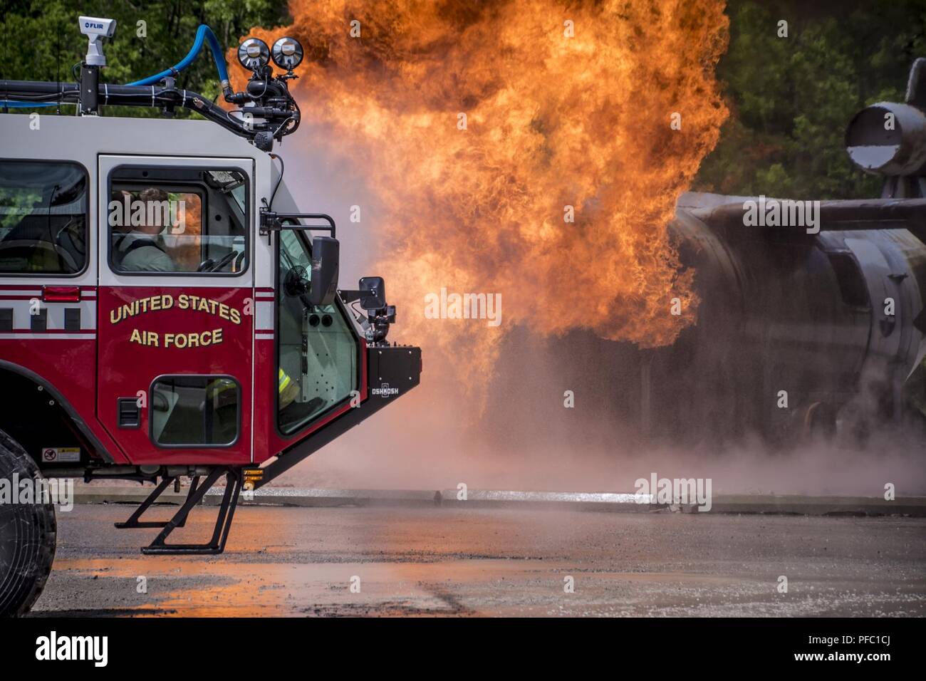 Flieger von der 179th Airlift Wing Feuerwehr, Mansfield, Ohio, Durchführung aircraft Crash Recovery Training, 4. Juni 2018, an der Alpena Combat Readiness Training Center, Alpena, Michigan statt. Flieger verwenden Löschfahrzeuge Kreis der simulierten Flugzeugabsturz Website und die Flammen durch eine kontrollierte Propan live Fire System erstellt, löschen. Das Training ist auf volle Spektrum Bereitschaft Vorbereiten der Tragfläche zu lokalen, staatlichen oder bundesstaatlichen Aktivierungen zu einem Momente bemerken zu reagieren. Stockfoto