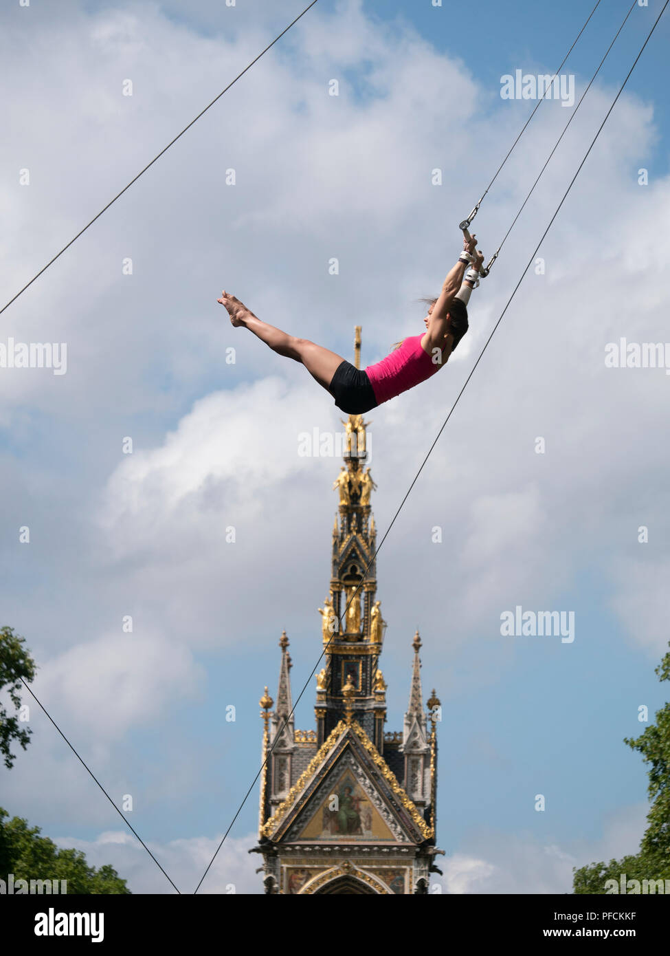 London, Großbritannien. 21 August, 2018. Junge Frauen Keep Cool in 27 c Hitze, indem sie über das Albert Memorial in Kensington, London zu fliegen. Sie sind Sie Training mit dem Fliegenden Trapez Schule (www.gorillacircus.com) Credit: David Thorpe/Alamy leben Nachrichten Stockfoto