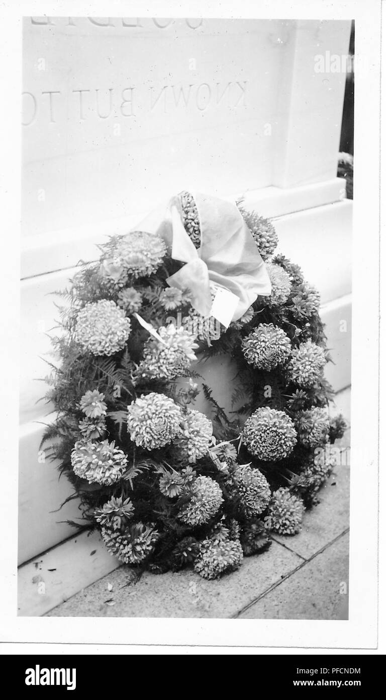 Schwarz-weiß Foto, mit einem Kranz von Chrysanthemen und Farne, mit einem hellen Bogen an der Spitze, ruhen auf der Basis einer Tombstone, Ehrenmal, oder ähnliche Memorial, vermutlich ehrt Soldaten während des Zweiten Weltkrieges getötet wurden, wahrscheinlich in Ohio, 1945 fotografiert. () Stockfoto
