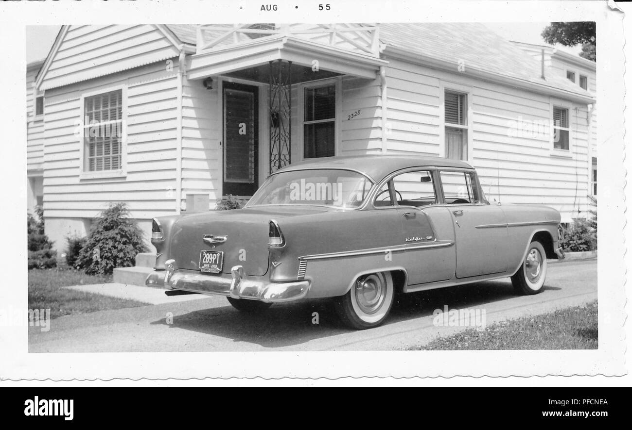 Schwarz-weiß Foto, zeigt ein zweifarbiges, Hardtop, Chevrolet Bel Air in einer Fahrstraße vor einem kleinen, hellen Haus geparkt, mit Abstellgleis und eine überdachte Veranda, wahrscheinlich in Ohio, August, 1955 fotografiert. () Stockfoto