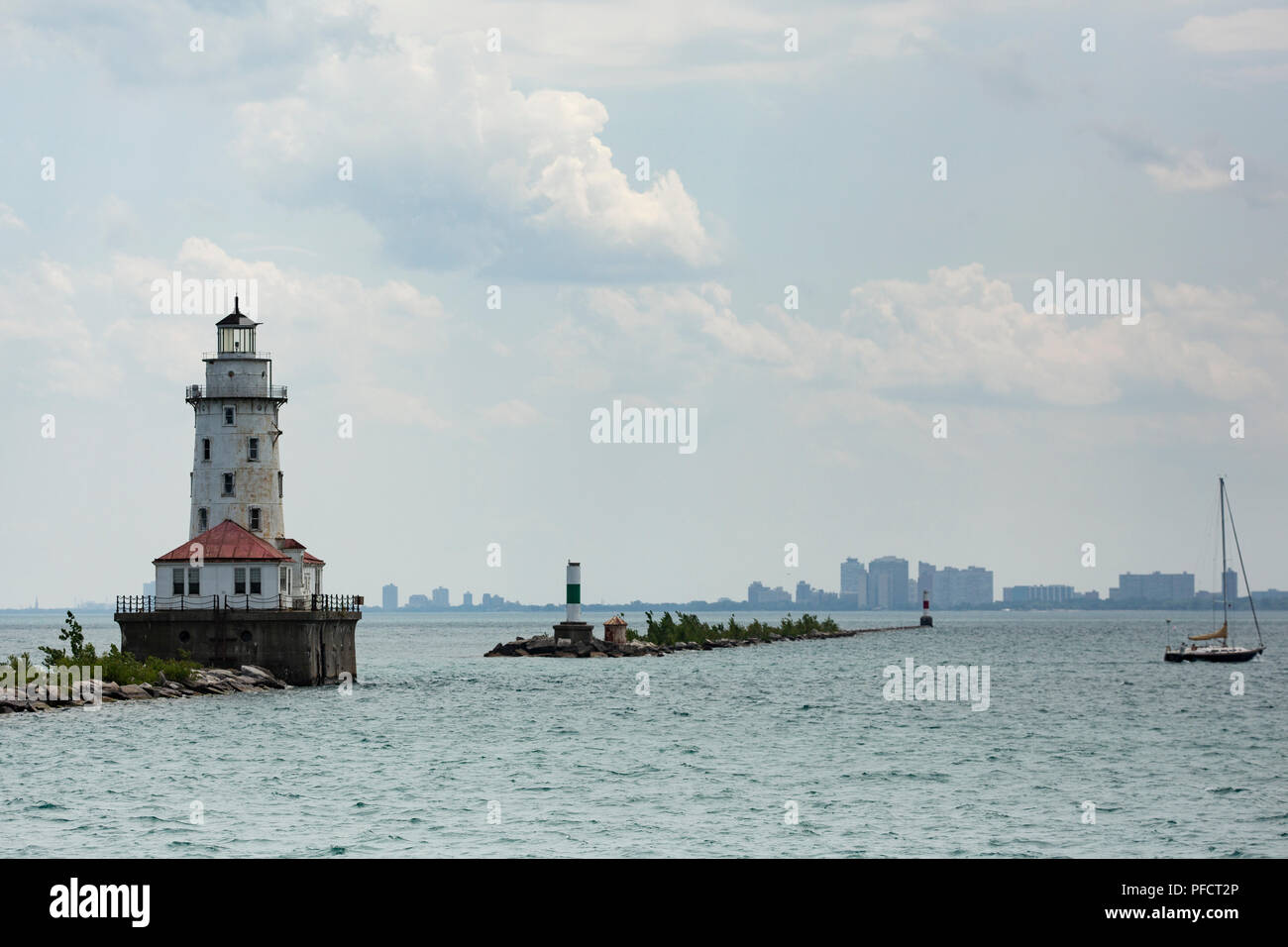 Die Chicago Hafen Leuchtturm mit Blick in Richtung der Stadt, mit einem Segelboot. Stockfoto