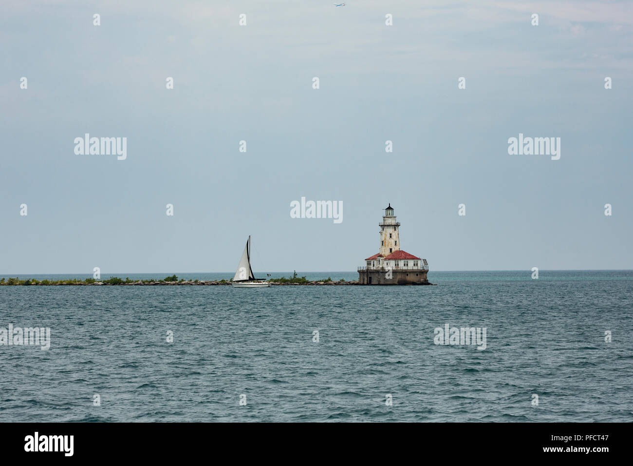 Blick auf den Hafen Leuchtturm Chicago am Lake Michigan mit einem Segelboot vorbei. Stockfoto