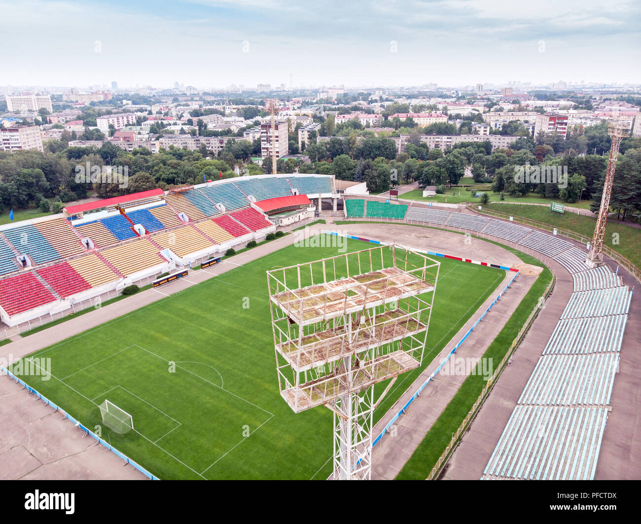 Stadt Sport Stadion. Fußballplatz und Tribünen mit bunten Sitze. Luftaufnahme Stockfoto