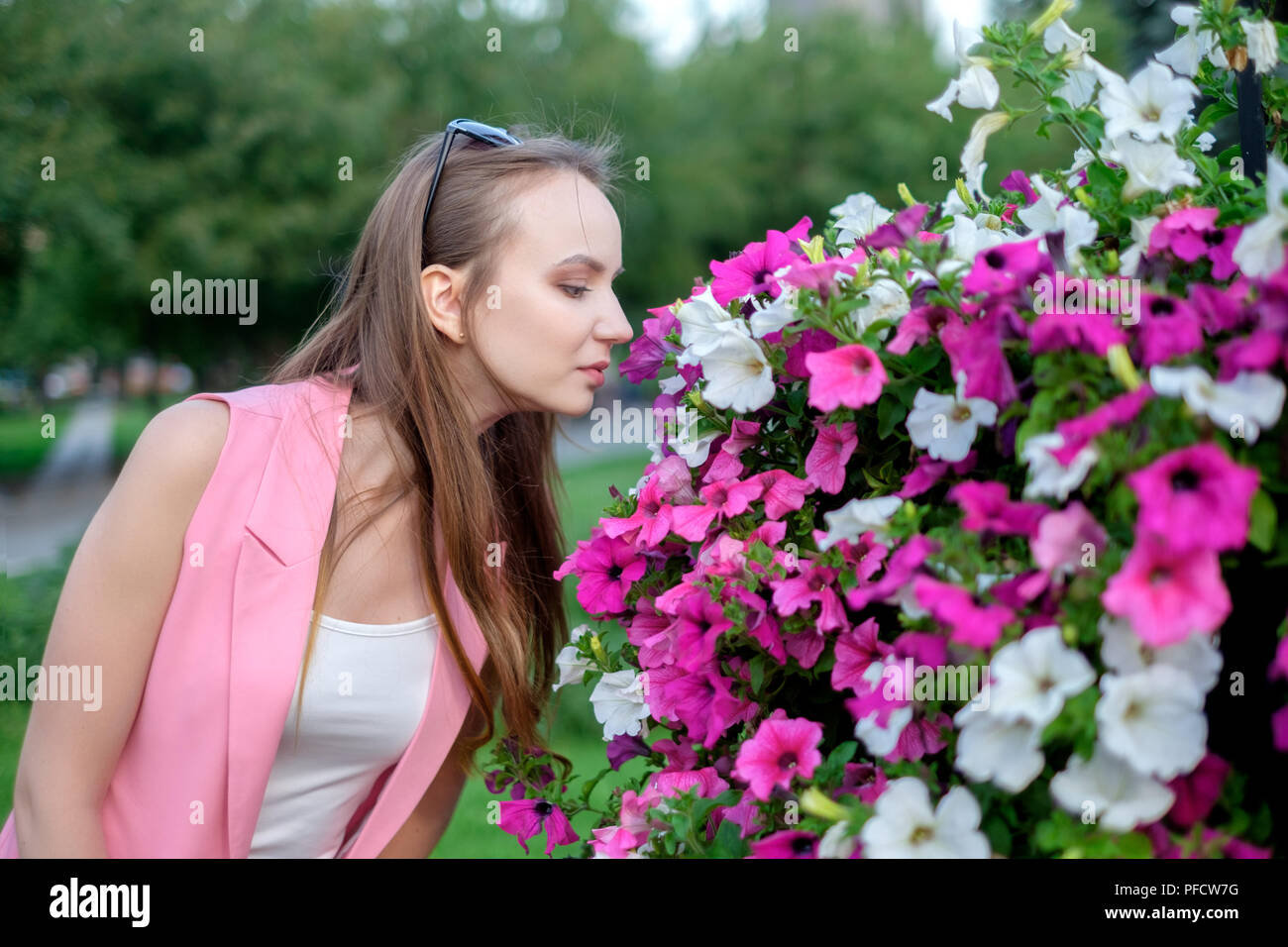 Seite Profil der jungen Frau riechenden Blüten Stockfoto