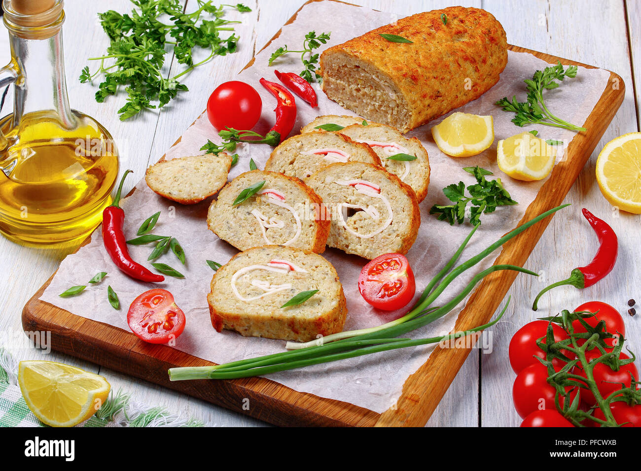 In der Nähe von köstlichen Backwaren in den Ofen Gefilte Hackfleisch/weißer Fischfilets Roll-up mit Krabbenfleisch in Scheiben geschnitten auf Schneidebrett mit frühlingszwiebeln, frische spr Stockfoto