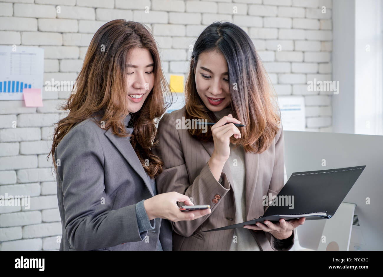 Zwei Kollegen Geschäftsfrau und Diskussion über die Arbeit mit mobilen mit Gefühl entspannen im Büro. Digital Business Lifestyle Konzept Stockfoto