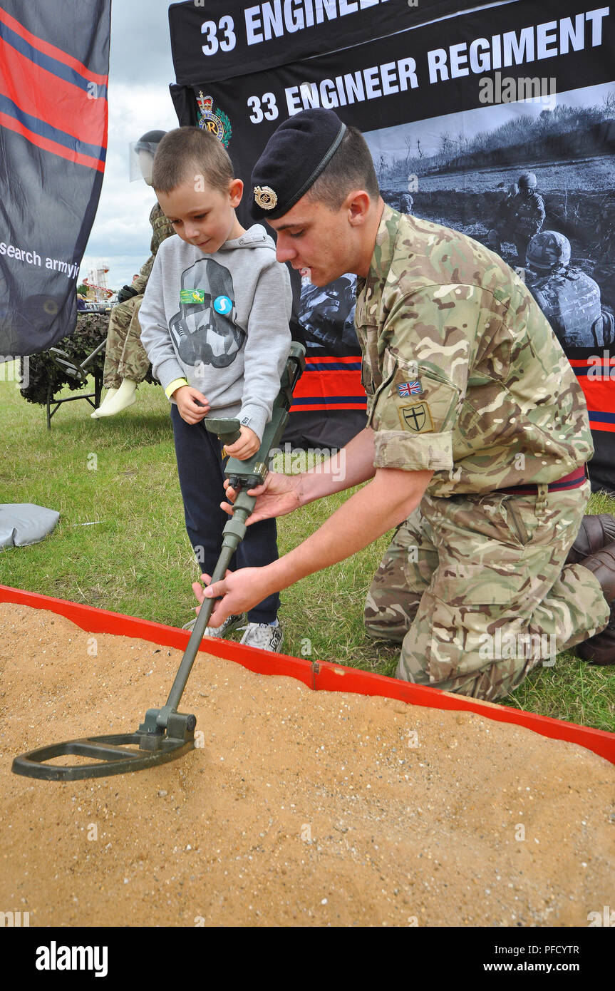 Britischer Soldat demonstriert Minenerkennung für ein Kind. Veranstaltung für Öffentlichkeitsarbeit. 33 Ingenieur-Regiment. Militär. Ereignis der Streitkräfte Stockfoto