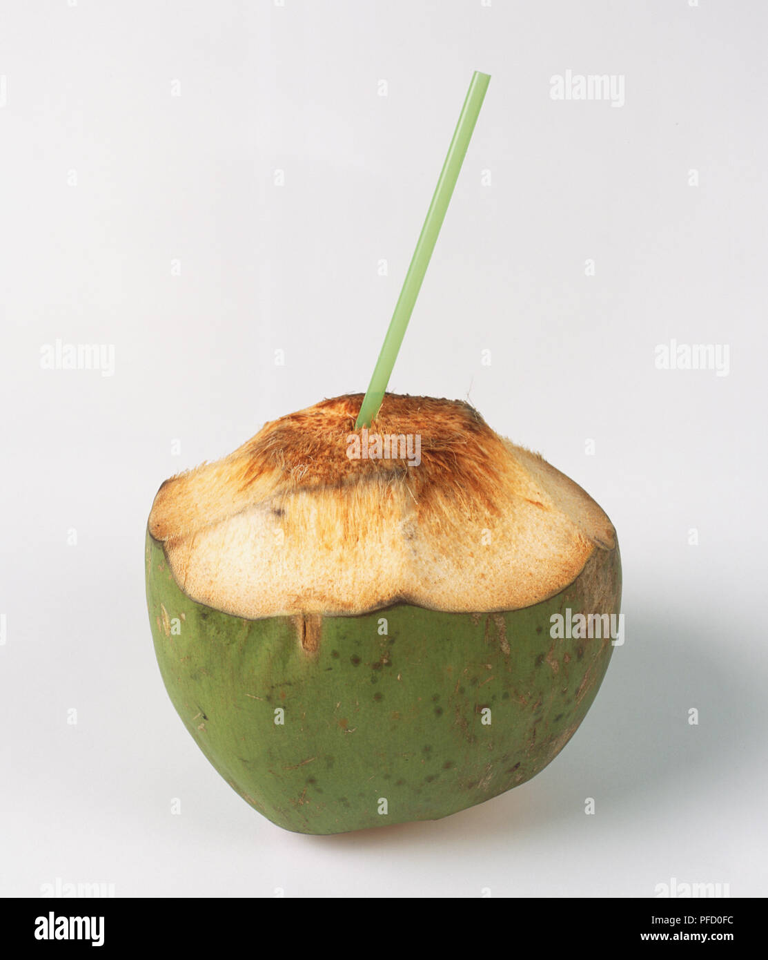 Teilweise geschält Kokosnuss mit Stroh in die oberen eingefügt, Seitenansicht. Stockfoto