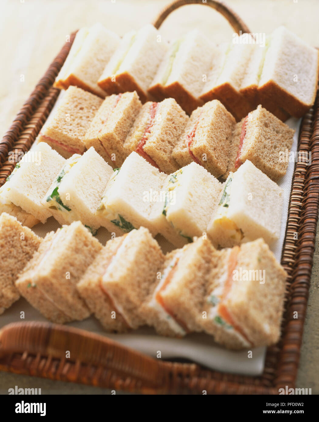 Sandwiches, weiche, weiße und braune Brot, mit verschiedenen Füllungen, auf rattan Fach dienen arrangiert, in der Nähe Stockfoto