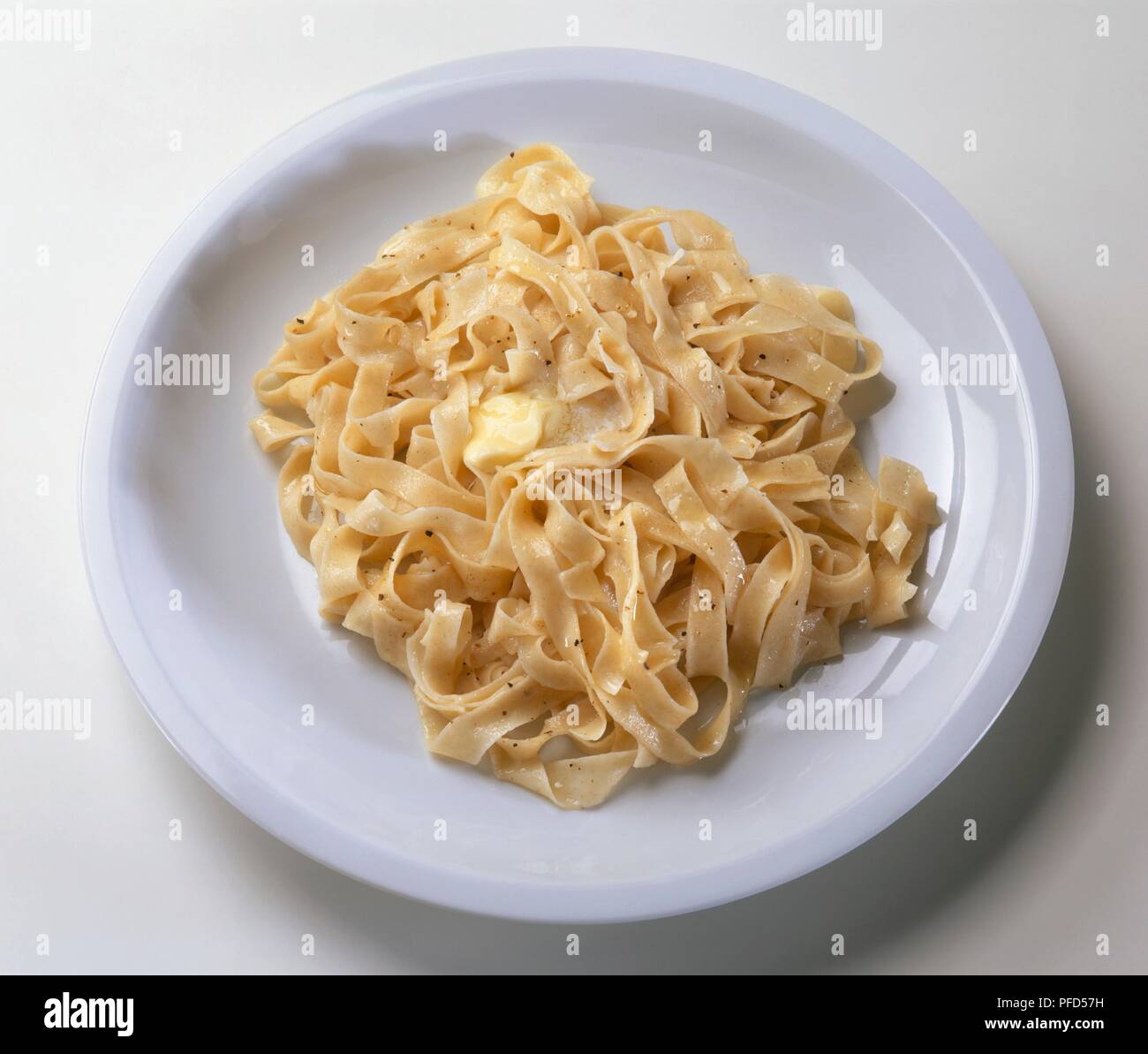 Fettucine serviert mit Butter und gemahlenen schwarzen Pfeffer auf weiße Platte Stockfoto