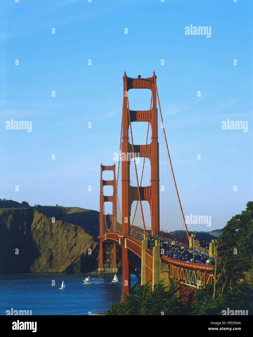 USA, Kalifornien, San Francisco, Golden Gate Bridge, Blick Richtung craggy Marin headlands über Verkehr - beladene Brücke, Segelboote im blauen Wasser unter, und blauer Himmel. Stockfoto