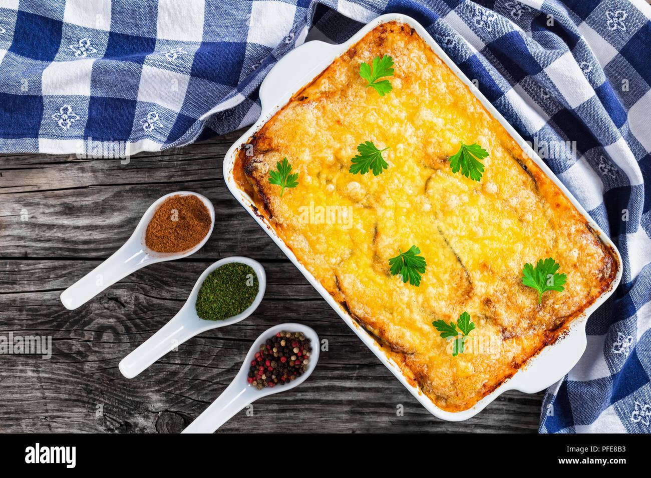 Moussaka, authentische Rezept - Schichten der Aubergine, Hackfleisch, Tomate, béchamelsoße Soße und Käse überbacken im Ofen in der auflaufform mit Küchentuch auf o Stockfoto