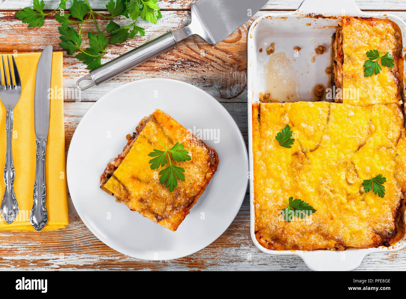 Teil der leckeren Moussaka auf Platte mit Messer und Gabel und in ... Teil der leckeren Moussaka auf Platte mit Messer und Gabel und in ...