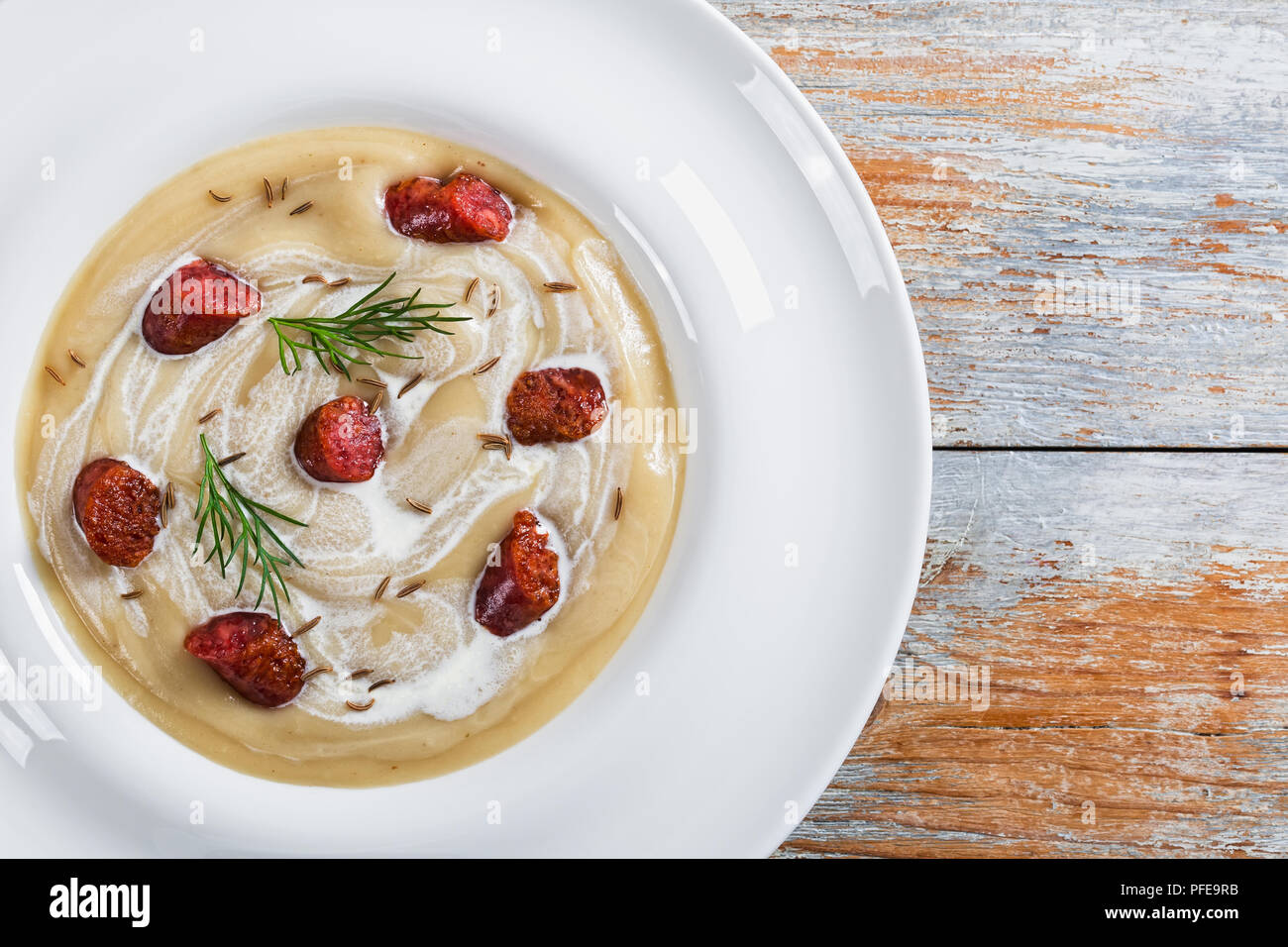 Lecker Bier und Creme würzige Suppe mit Kielbasa Wurst, Dill. und Käse in weiten rim die Platte an der weißen Farbe blättert von den Boards, authentische Rezept, fr Stockfoto