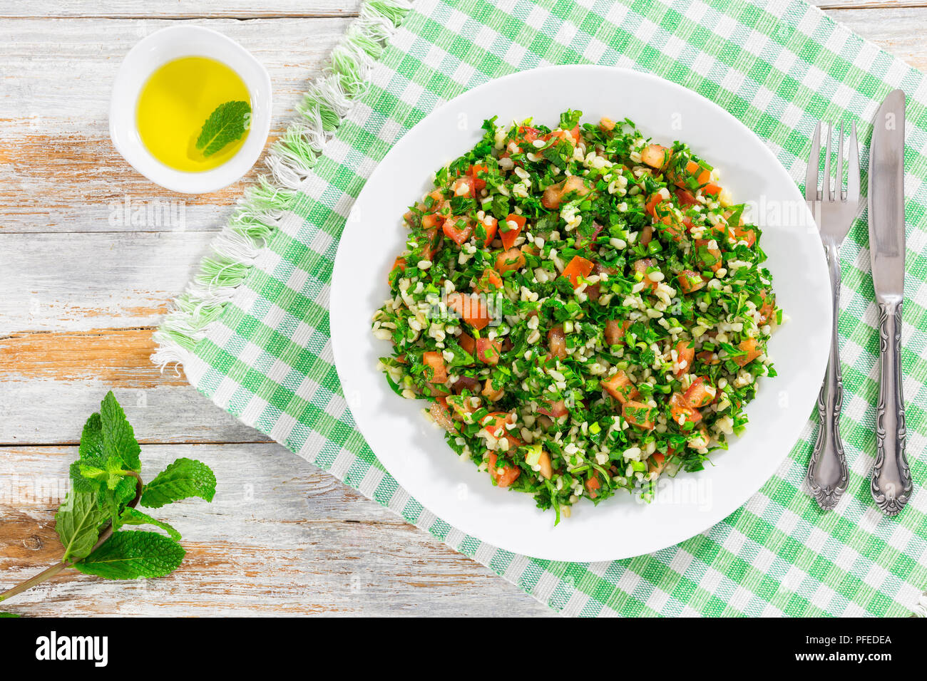 Petersilie Salat oder Tabbouleh, Naher Osten vegetarisches Gericht mit Bulgur, Tomaten, Petersilie, Frühlingszwiebeln und Minze, bestreut mit Olivenöl und Zitrone Stockfoto