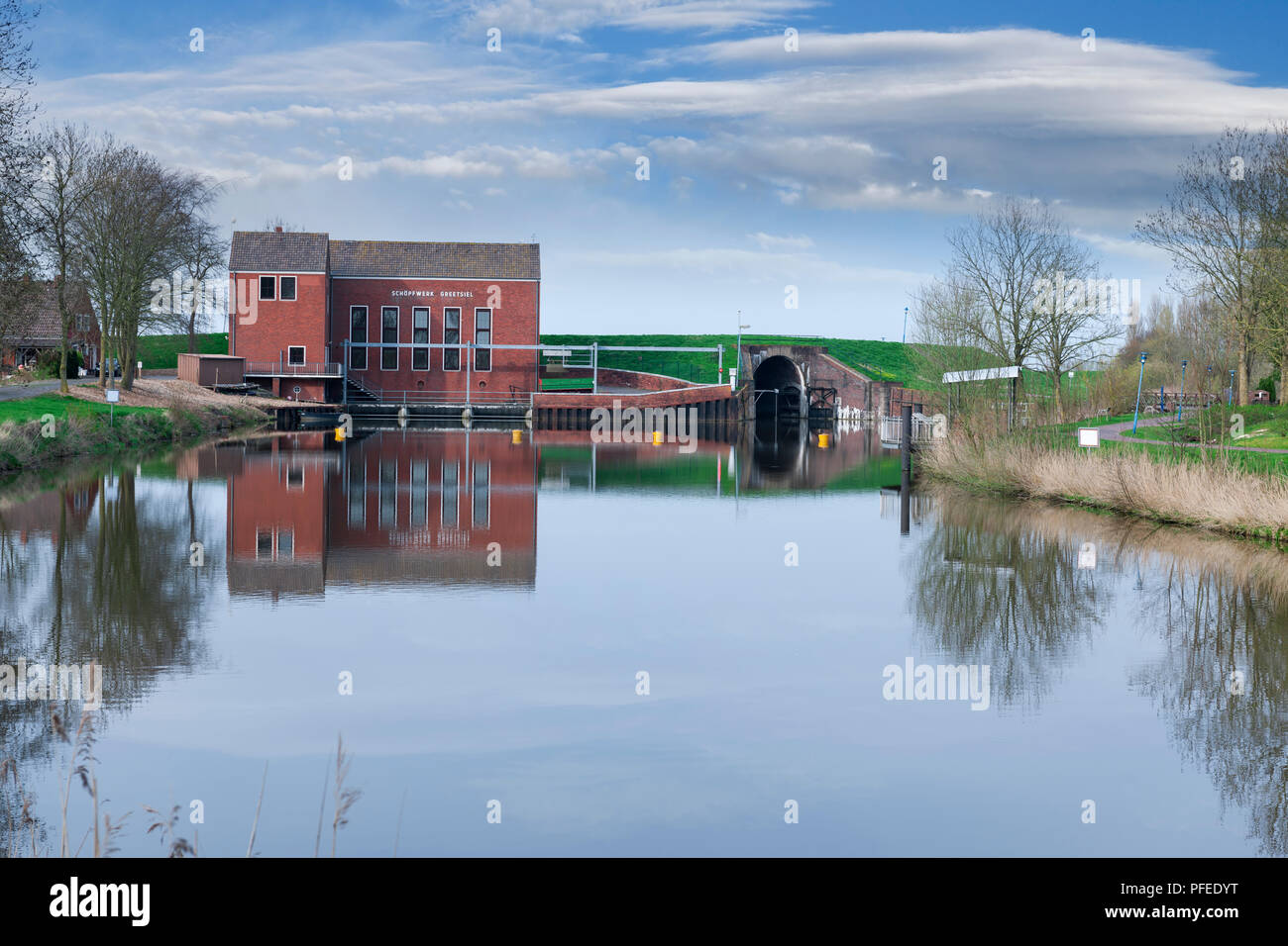 Blick über den Binnenschiffsverkehr Binnenmude auf der Alten, 1957 Pumpstation in Greetsiel mit Deich und Sieltor sperren Stockfoto