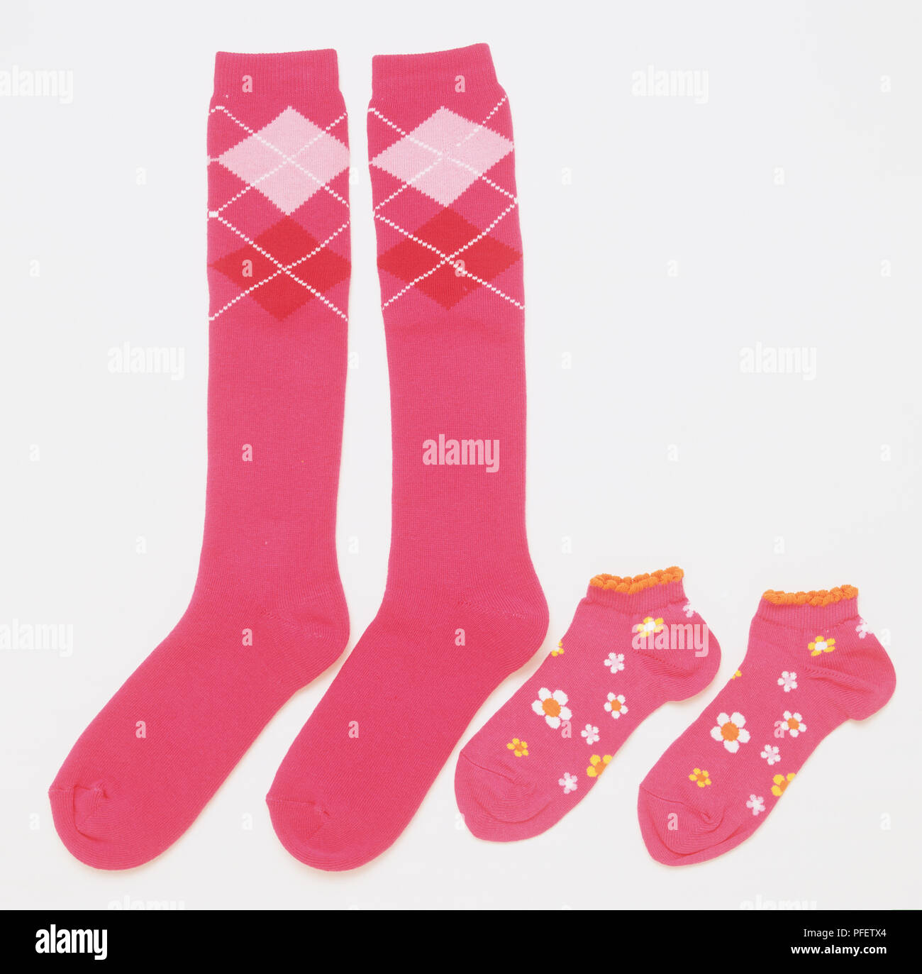 Ein paar Kniestrümpfe rosa Socken neben anderen bezahlt der rosa blühenden gemusterten Söckchen. Stockfoto