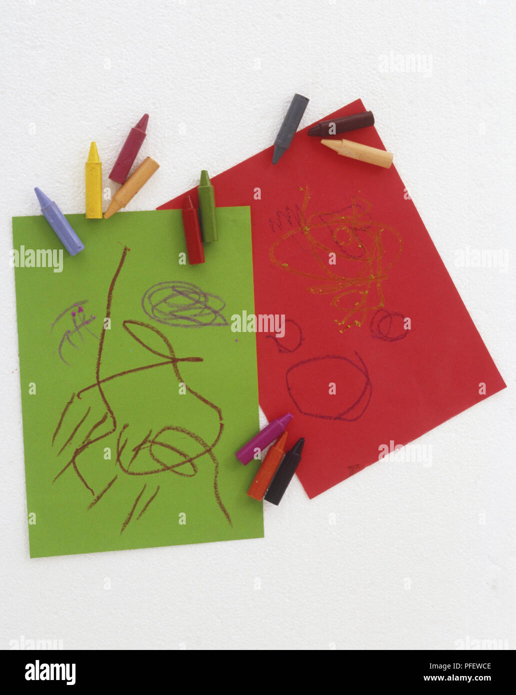 Gekritzel auf Stücke von grünen und roten Papier, mit einer Auswahl von farbigen Kreiden Stockfoto