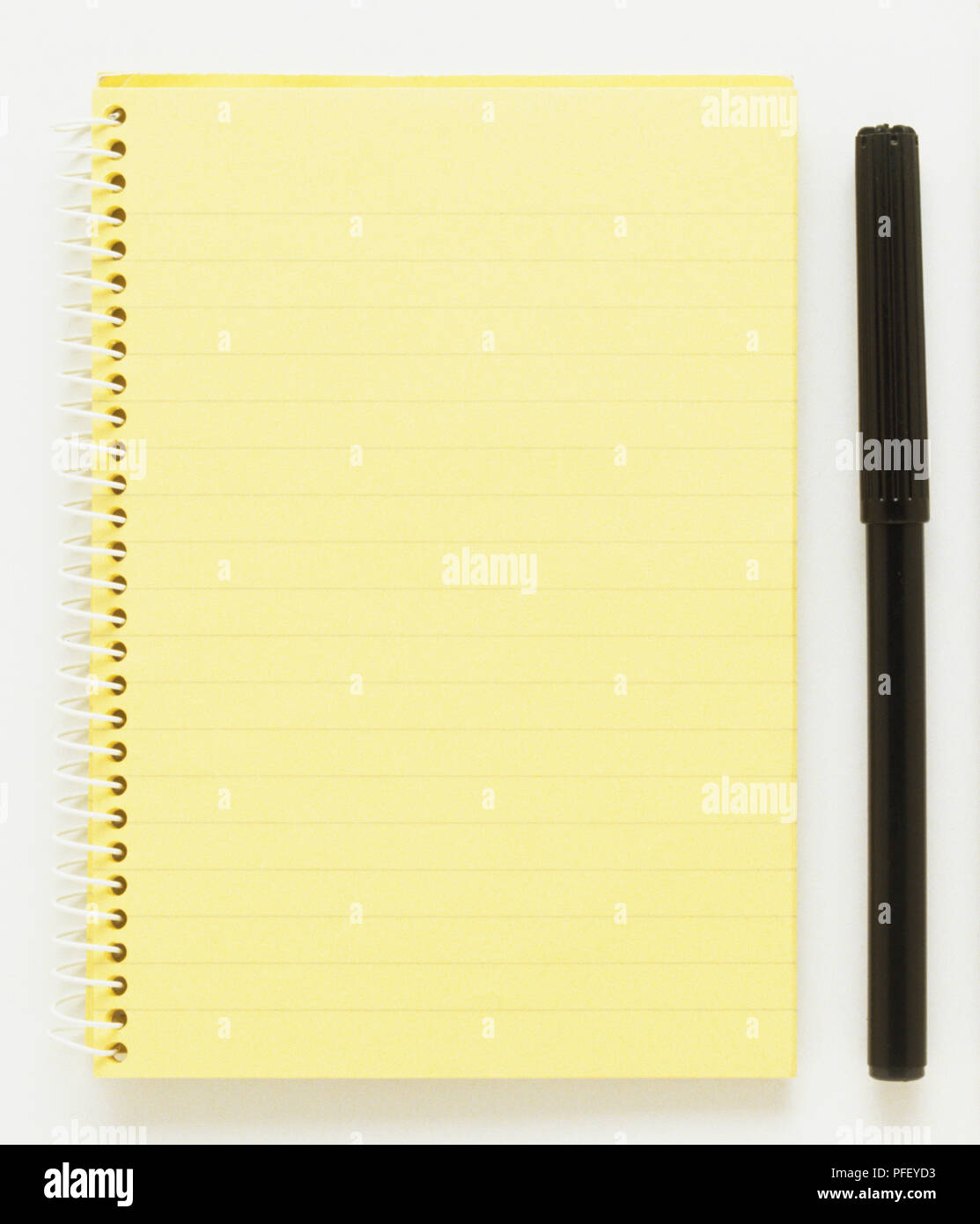 Spirale Notizblock mit gesäumt, gelbes Papier, einen Stift und einen weißen Stift Stockfoto