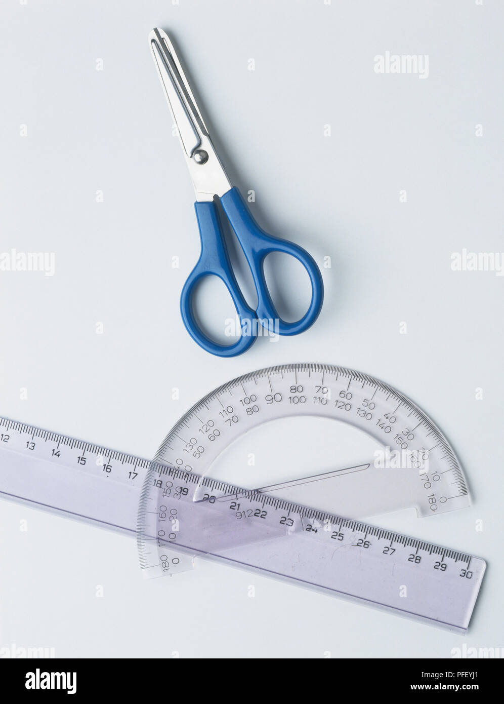 Lineal, winkelmesser Halbkreis und Schere mit blauen Griffen Stockfoto
