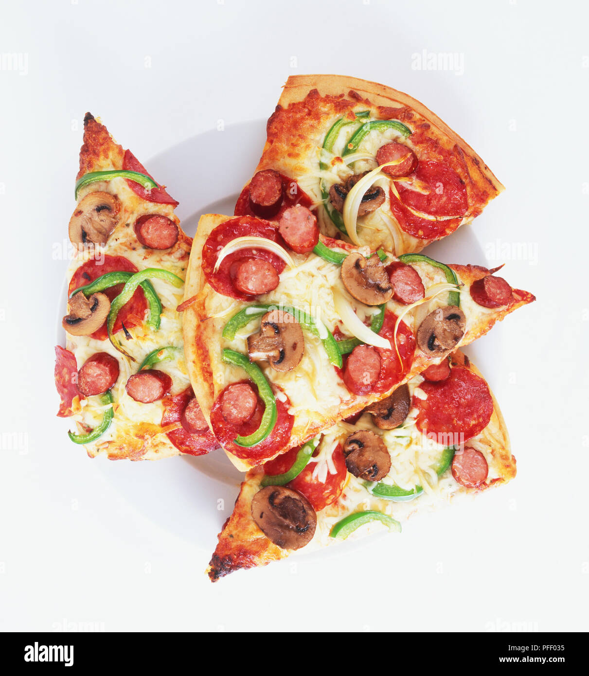 Vier Scheiben pizza belegt mit Wurst, Champignons, grüne Paprika und Zwiebel Ringe Stockfoto