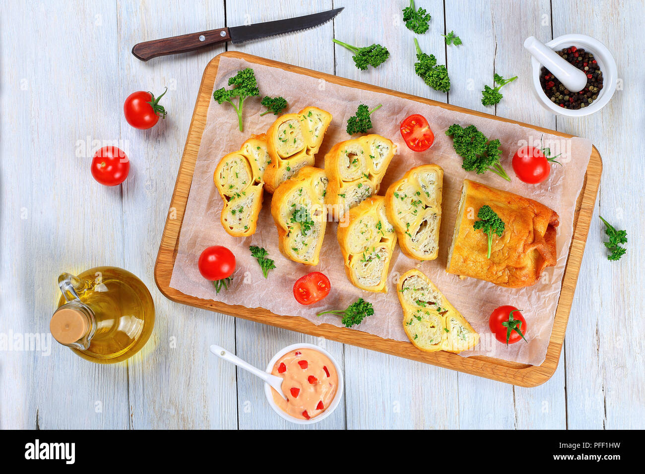Gerösteten Fladenbrot Wraps mit Hackfleisch Huhn Fleisch und Käse in Scheiben geschnitten auf Schneidebrett mit frischer Petersilie und Tomaten gefüllt, close-up Stockfoto