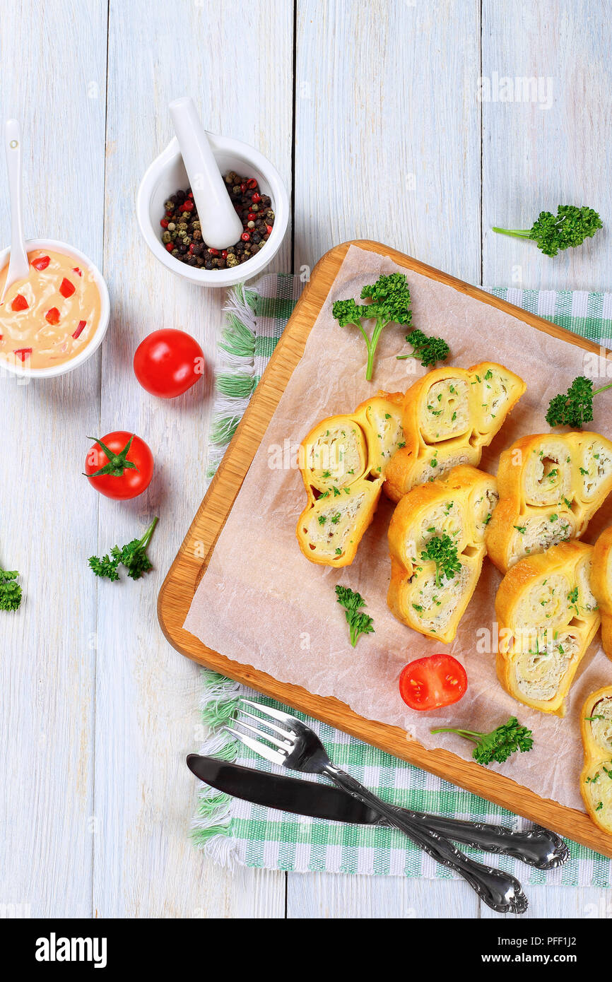 Crepes Brötchen mit gehacktem Hühnerfleisch, Cottage und Kräuter in Scheiben schneiden auf Schneidebrett mit frischer Petersilie und Tomaten, Sauce mit Pep gefüllt Stockfoto
