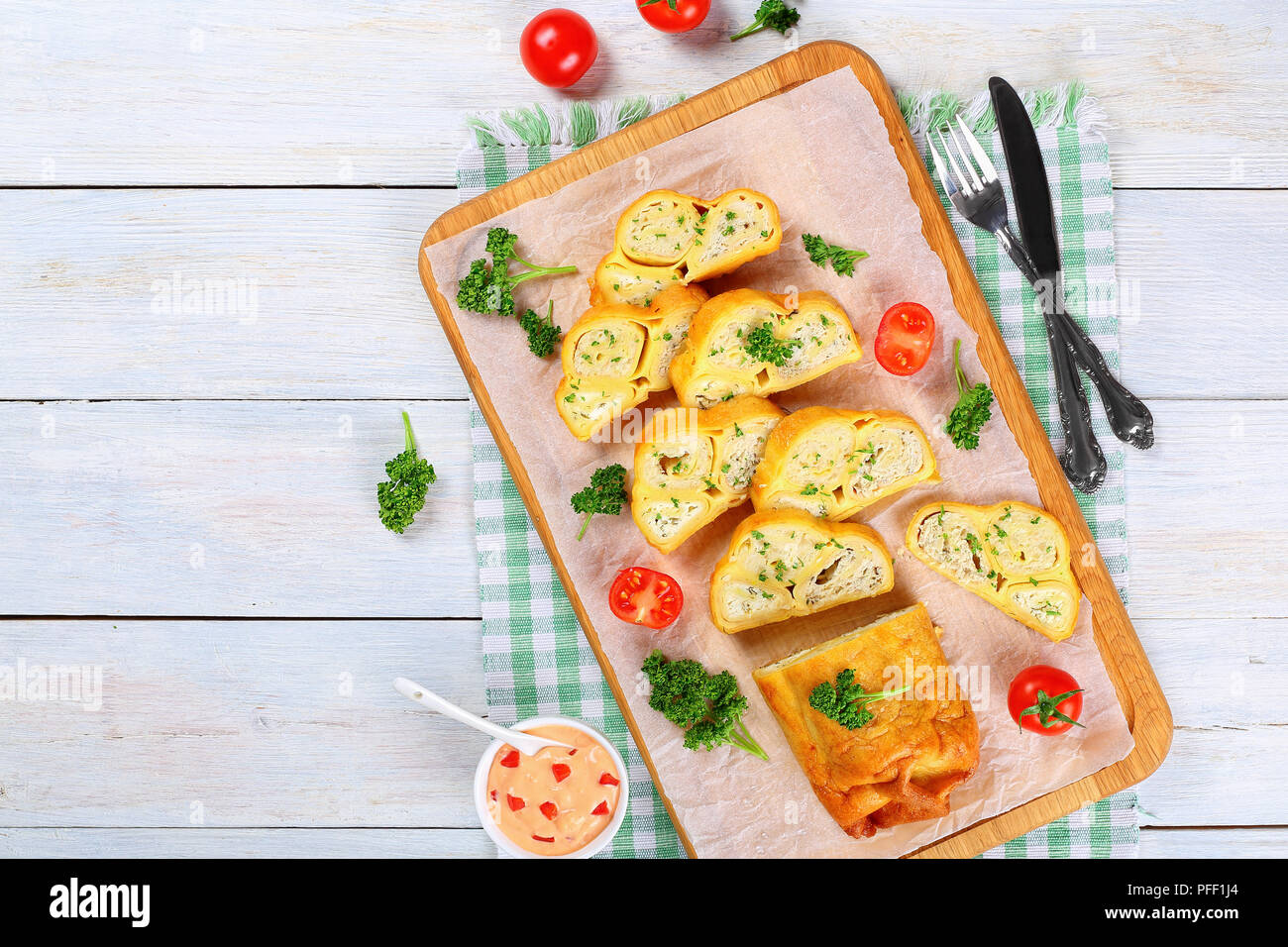 Crepes Brötchen mit gehacktem Hühnerfleisch, Cottage und Kräuter in Scheiben schneiden auf Schneidebrett mit frischer Petersilie und Tomaten, Sauce mit Pep gefüllt Stockfoto