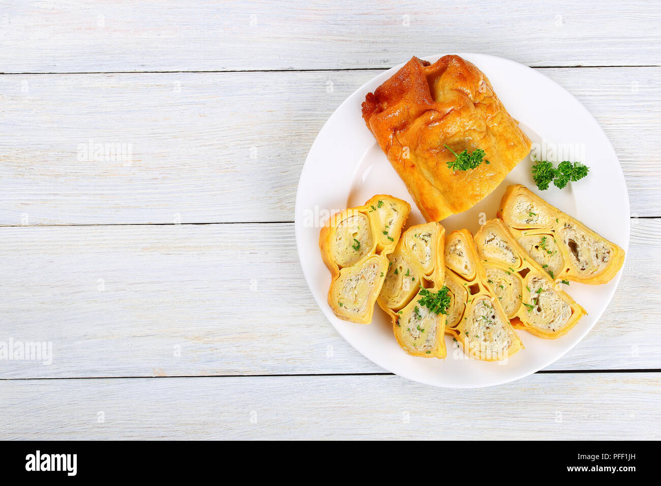 Im Ofen gebacken köstliche Crepes Brötchen Kuchen mit gehacktem Hühnerfleisch, Cottage und Kräuter in Scheiben schneiden auf weiße Platte Holzbretter gefüllt, Ansicht von ab Stockfoto