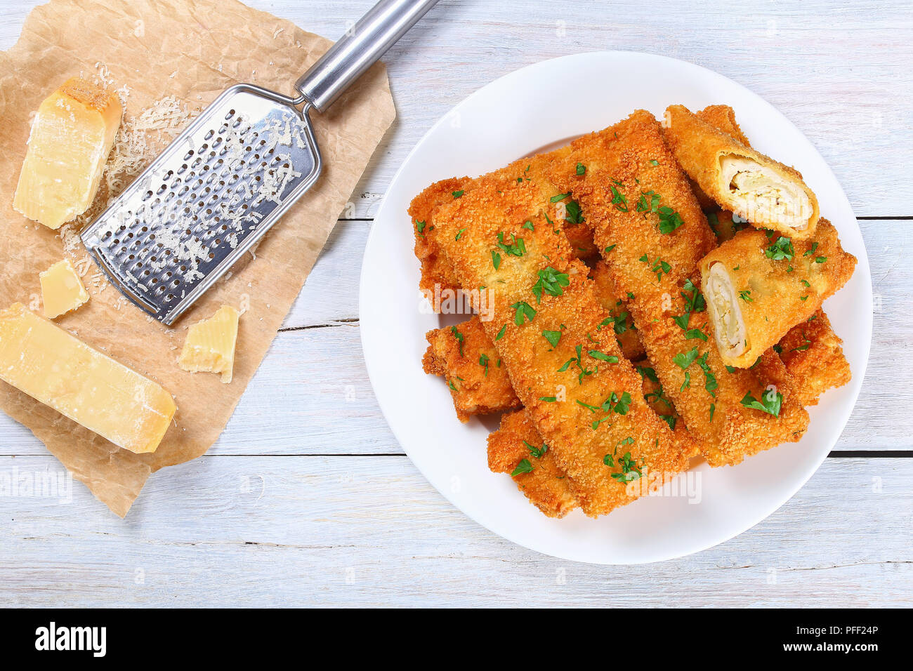 Lecker Knusprig paniert Gebackene Hackfleisch Huhn Enchiladas ganze und Schneiden auf weiße Platte, Stücke von Käse und reibe auf Holztisch, Ansicht von Stockfoto