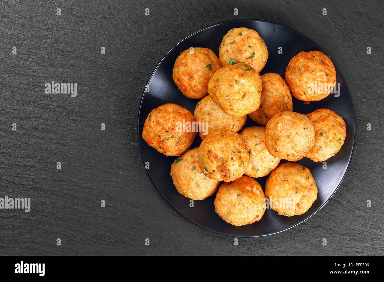 Lecker gebratene Fleischbällchen aus Hackfleisch, Semmelbrösel, Gewürzen und Petersilie auf schwarze Platte auf dunklem Stein Fach, klassisches Rezept, Ansicht von oben Stockfoto
