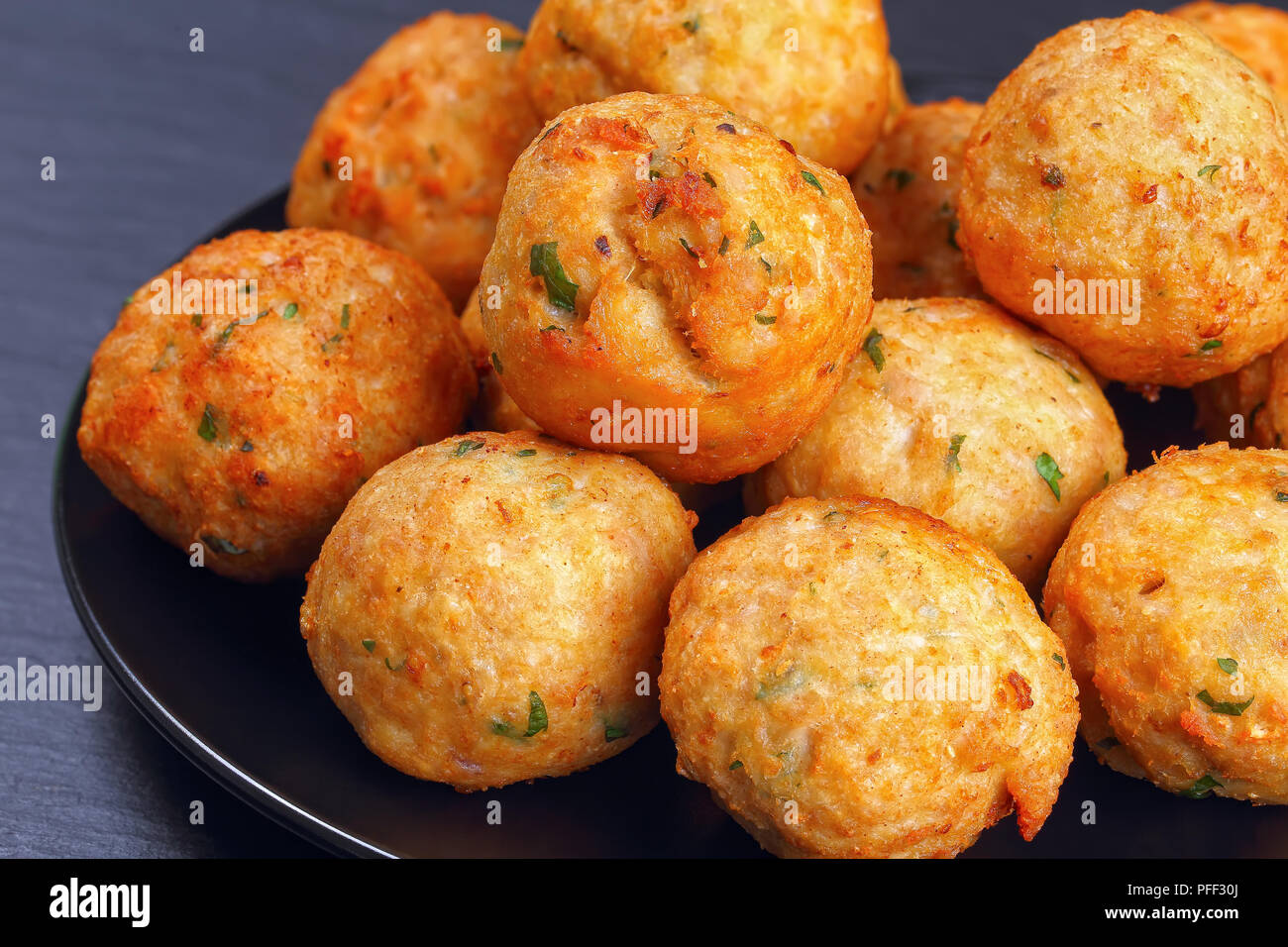 Lecker gebratene Fleischbällchen aus Hackfleisch, Semmelbrösel, Gewürzen und Petersilie auf schwarze Platte auf dunklem Stein Fach, klassisches Rezept, Nahaufnahme, Ansicht von vorne f Stockfoto