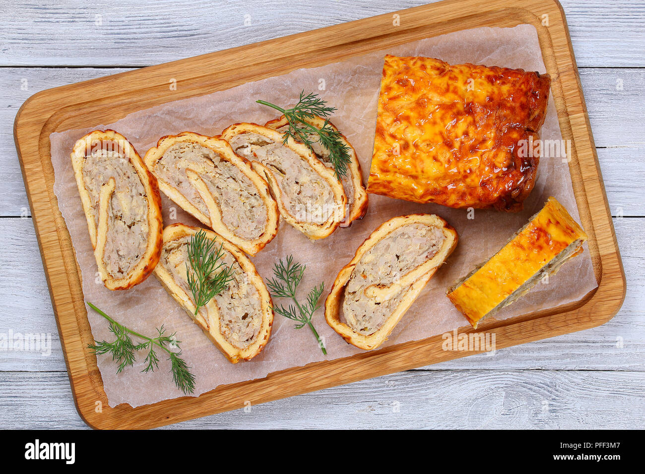 Würziges Hackfleisch Huhn Pilze Roll-up Laib mit Dill in Scheiben geschnitten auf Papier auf Schneidebrett auf Holz- Tabelle, Ansicht von oben Stockfoto