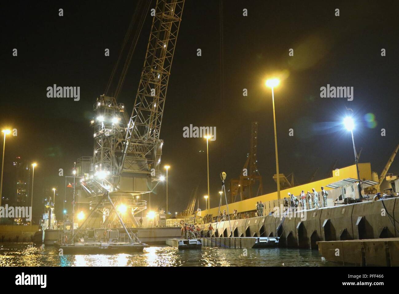 SHUIABA PORT, Kuwait - Als nautische Horizont 2018 startete diese Woche, Mitglieder der 331 Transport Unternehmen arbeiten mit der 38Th Sustainment Brigade der Lastkahn Derrick Kran verwenden, um Zeichenfolgen der Internationalen Organisation für Normung (ISOPAK) Module in den Hafen, so dass Sie den Roll-on/Roll-off-Entlastung für die Logistik-über-die-Shore mission Hoist. Nautische Horizont 2018 ist eine 2-stufige U.S. Army Central Stockfoto