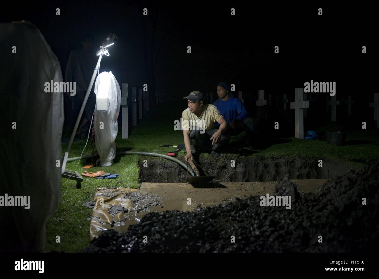 Die einheimischen Arbeiter mit der American Battle Monuments Commission (ABMC) Pumpe Wasser aus einem Grab an der Manila American Cemetery und Denkmal in Manila, Philippinen, 13. Juni 2018. ABMC arbeitete mit der Verteidigung POW/MIA Accounting Agentur (DPAA) zu exhumieren die Überreste von 23 Gräber als Teil der DPAA der Aufwand für Personal, das in der cabanatuan Kriegsgefangenenlager während des Zweiten Weltkriegs starb identifizieren. Es gibt mehr als 900 US-Mitglieder, die aus dem Gefängnis in Vergessenheit geraten sind. DPAA's Mission ist es, die möglichst vollständige Buchhaltung unserer fehlt Personal zu ihren Familien und der Nation zu stellen. Stockfoto