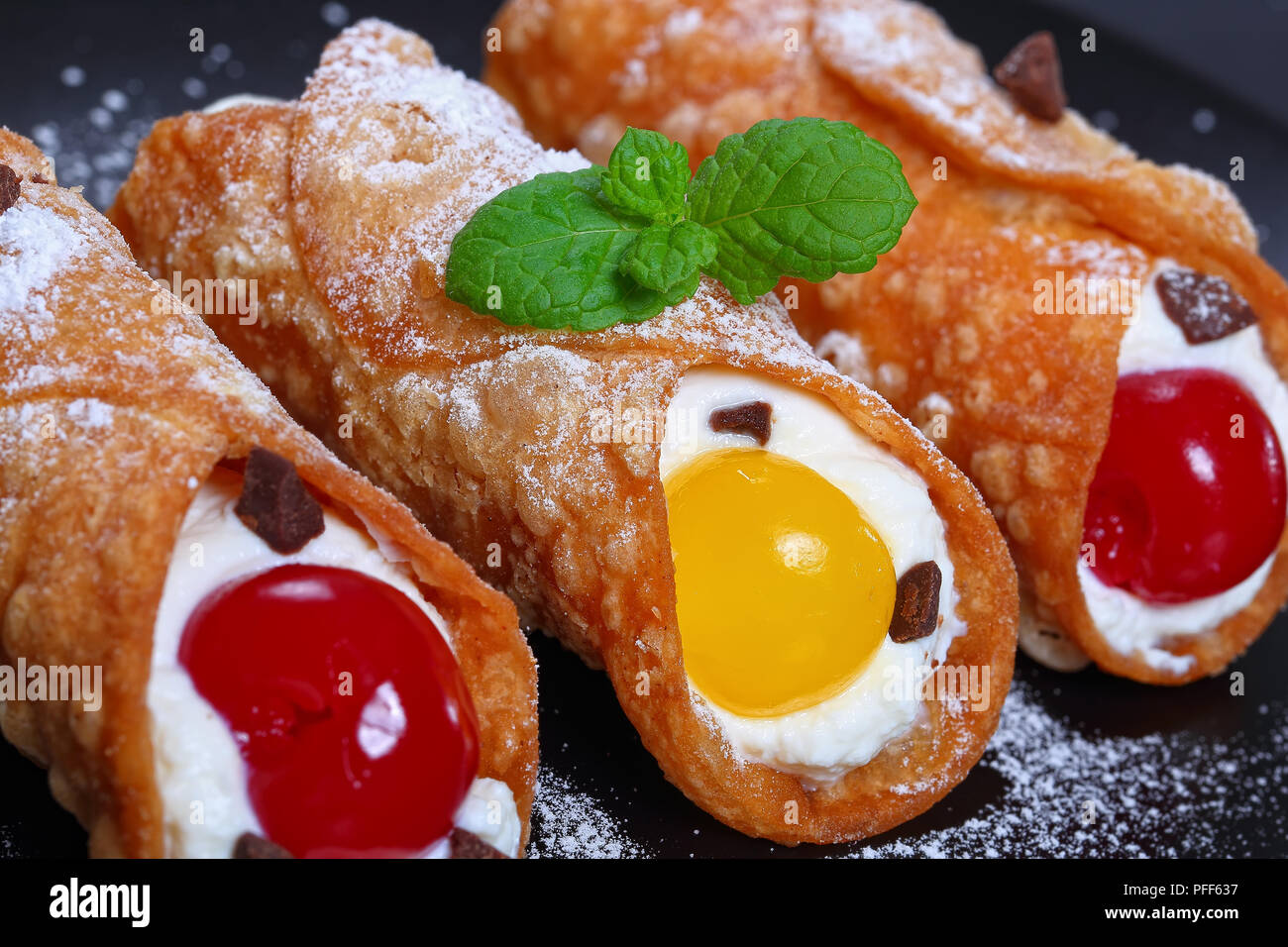 Köstliche hausgemachte sizilianische Cannoli - traditionelle italienische Dessert, Füllung mit Ricotta Käse auf schwarze Platte auf dunklem Schiefer Fach, authentische Klassische re Stockfoto