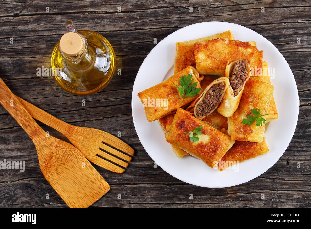Hackfleisch und Leber Gefüllte Crepes Crisped in Olivenöl auf weiße Platte auf alten Holz- Tabelle, Ansicht von oben Stockfoto
