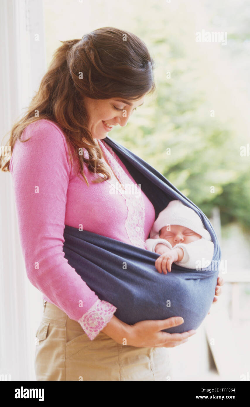 Frau mit beiden Händen Baby in weichen Tuch gehalten um ihren Körper schlang zu unterstützen. Stockfoto