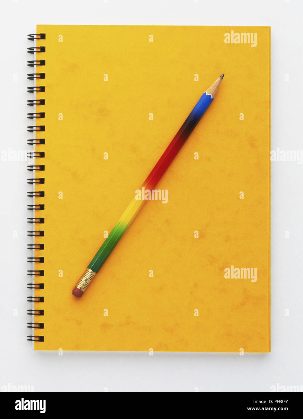 Bleistift gelegt über Notepad mit gelben Deckel, Vorderansicht Stockfoto