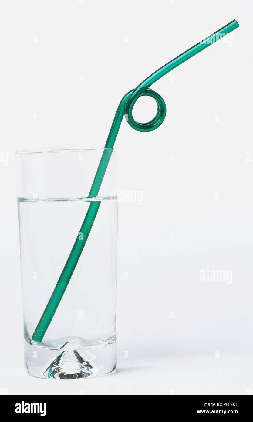 Grünen Trinkhalm in Schleife in einem Glas Wasser verdreht Stockfoto