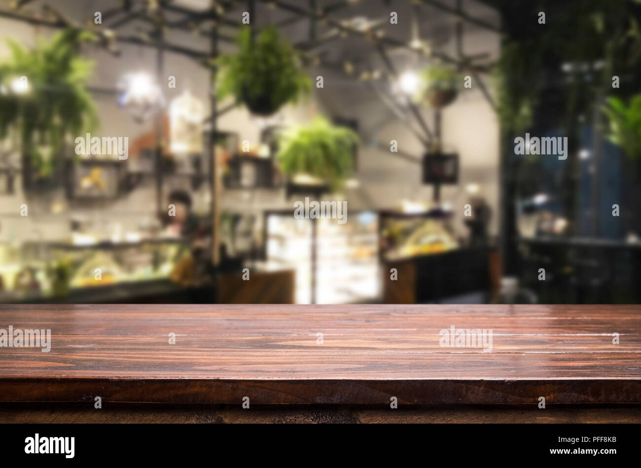 Ausgewählte Schwerpunkte leere braune Holztisch und Café oder Restaurant blur Hintergrund mit bokeh Bild. Für ihre Fotomontage oder des Produkts angezeigt. Stockfoto