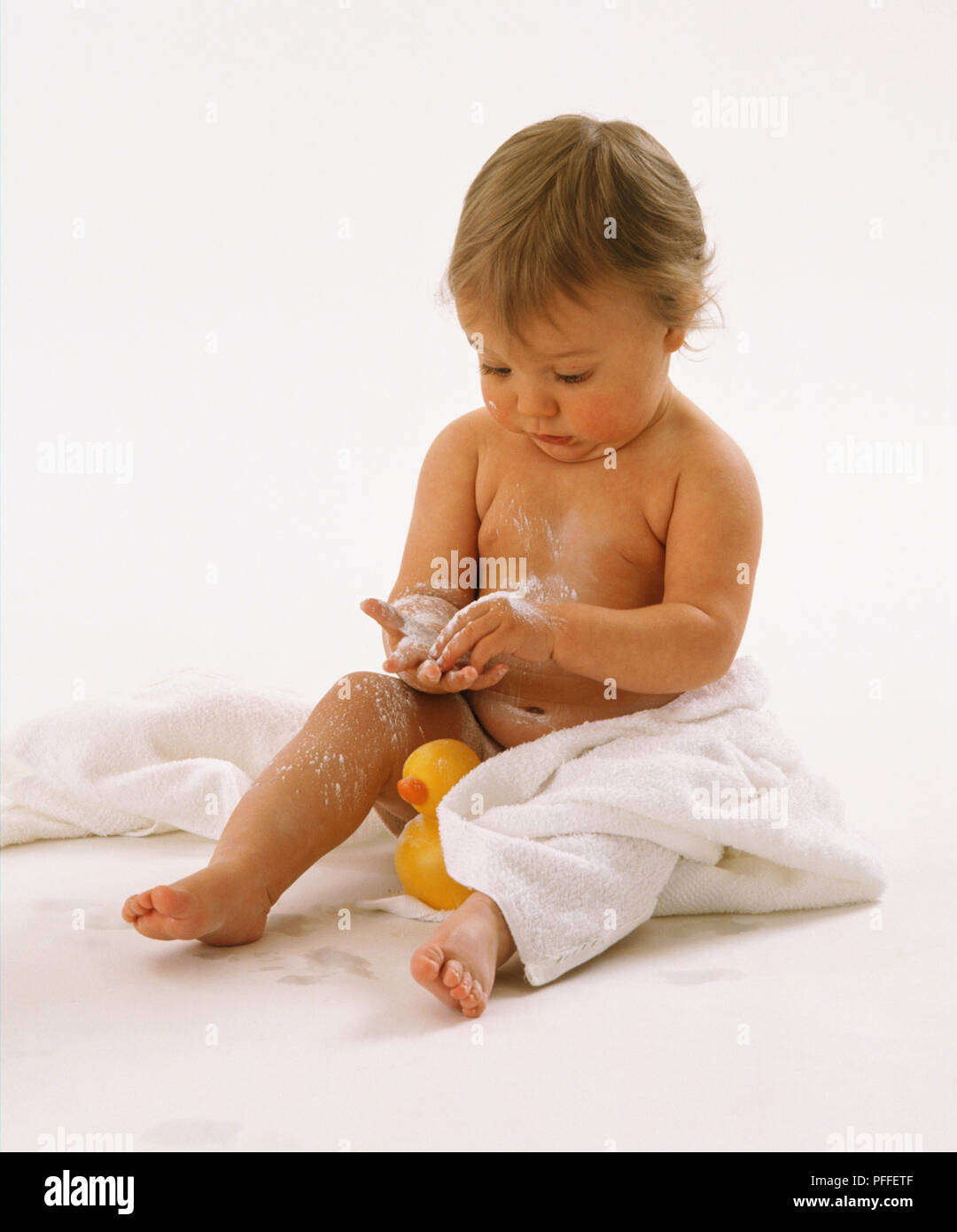 Kleinkind sitzen auf dem Boden, in weißen Handtuch