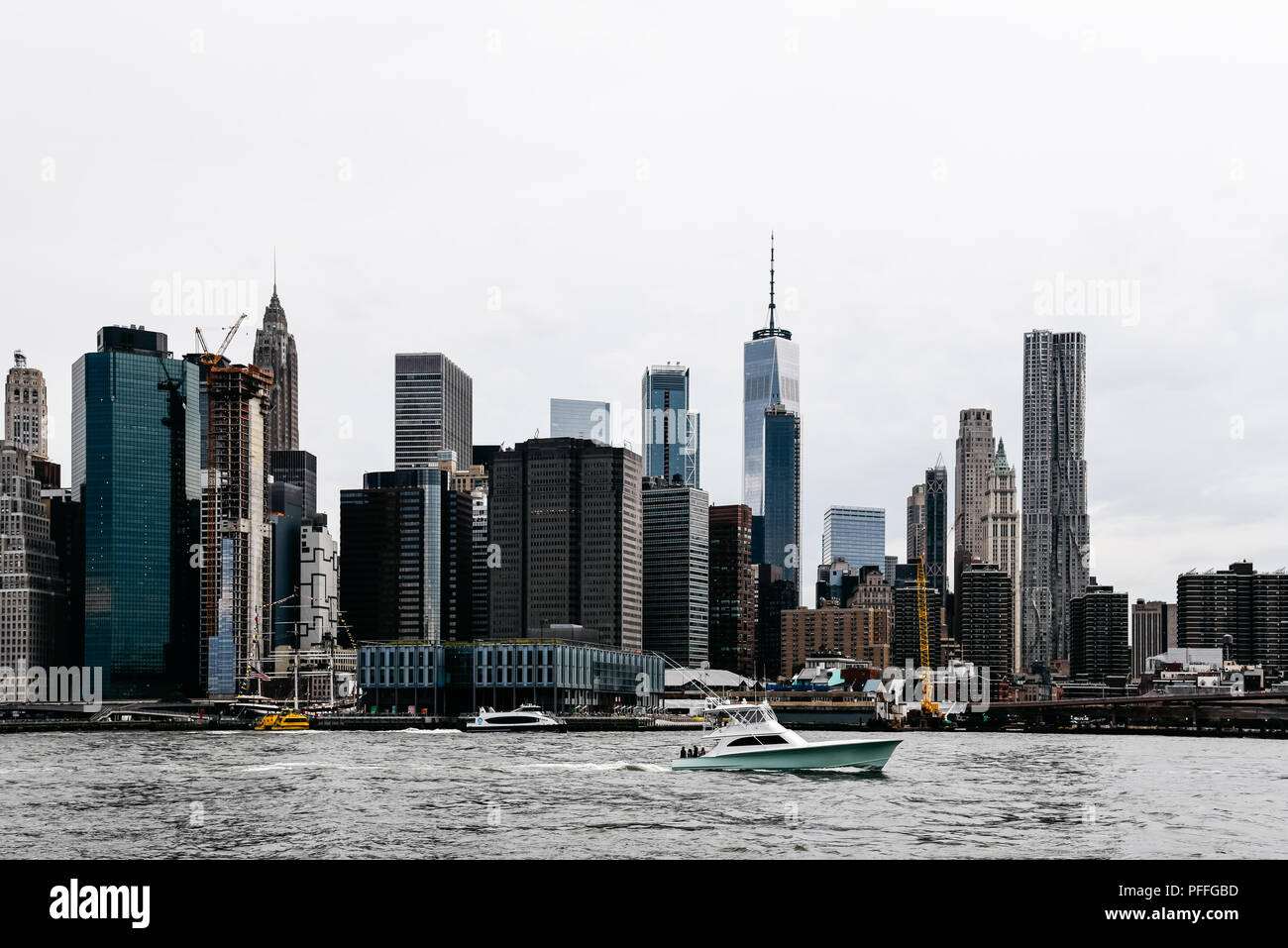 New York City, USA - 20. Juni 2018: Yatch am East River und Downtown Skyline im Hintergrund ein bewölkter Tag. Stockfoto