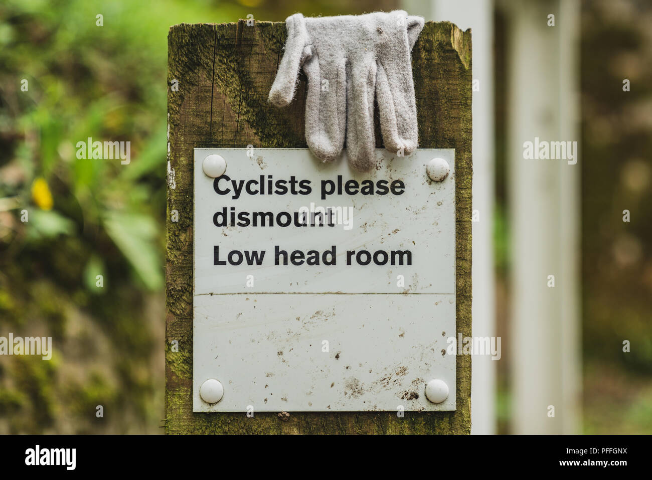 Zeichen: Radfahrer bitte, niedrigen Raum abbauen - mit einem Handschuh, Llangollen Canal in der Nähe von Ellesmere, Shropshire, England, UK gesehen Stockfoto