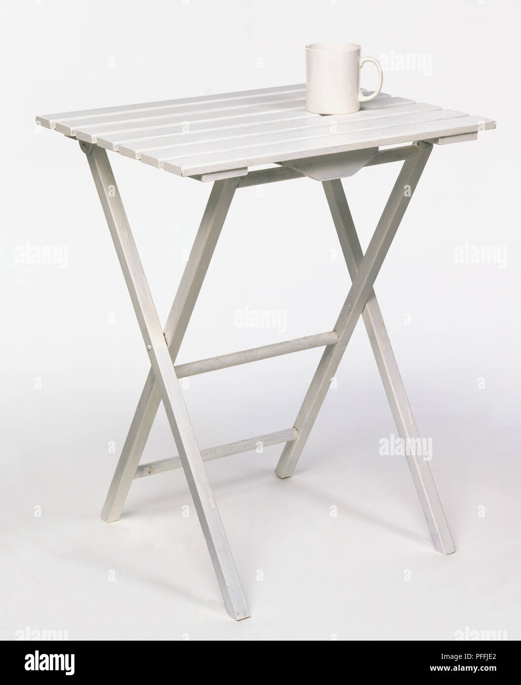Einfache, lattenrost, zusammenklappbare Tisch weiß gestrichen, mit einem China Tasse platziert. Stockfoto