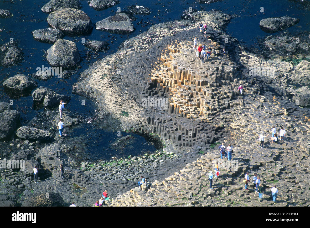 Nordirland, County Antrim, Giant's Causeway, Touristen zu Fuß auf Basaltsäulen, hohe Betrachtungswinkel Stockfoto