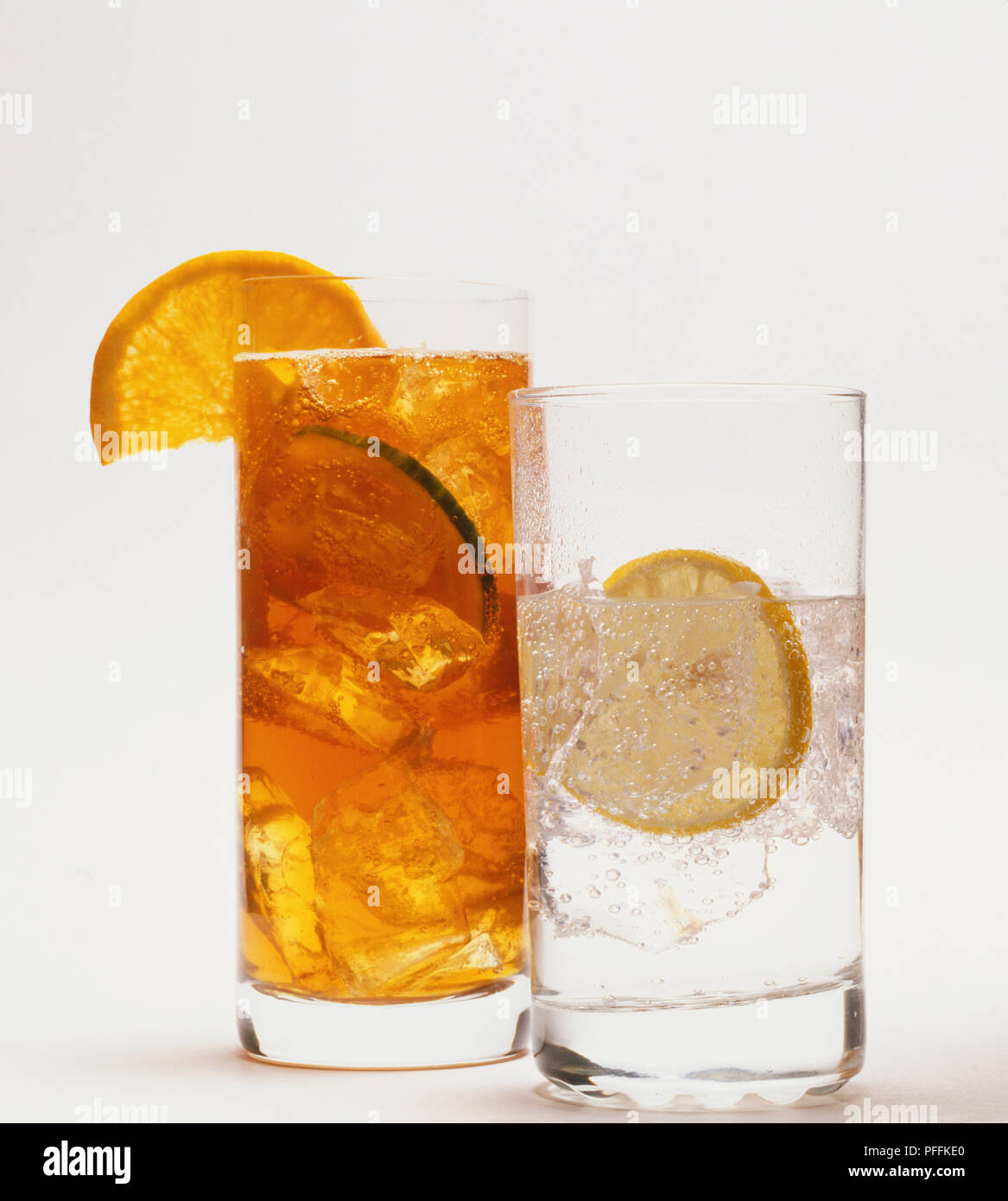 Glas Pimms und Glas Gin und Tonic, beide mit Eis und Zitrone Schichten. Stockfoto