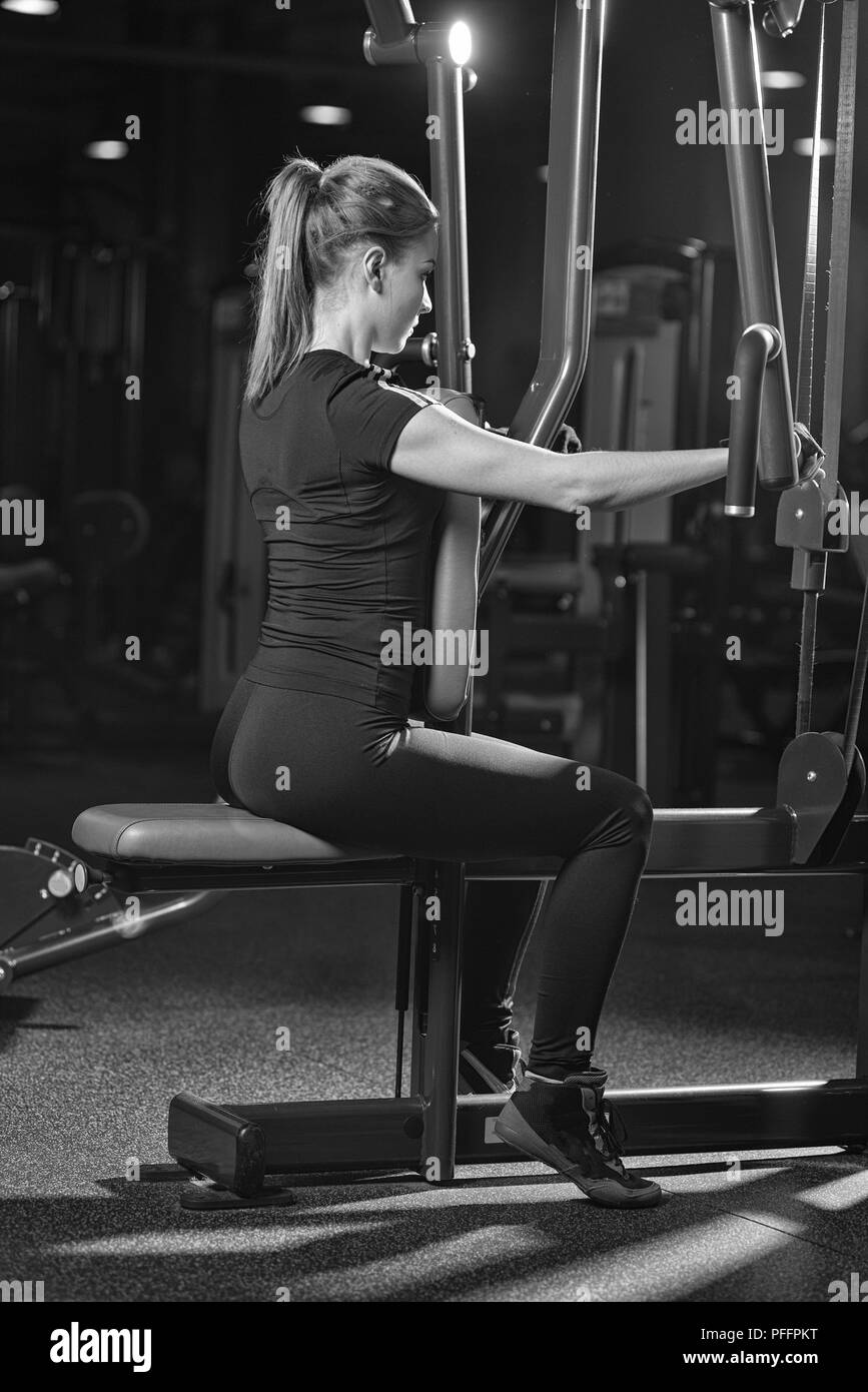 Frau an der Sporthalle Arme Übungen auf einer Maschine Stockfoto