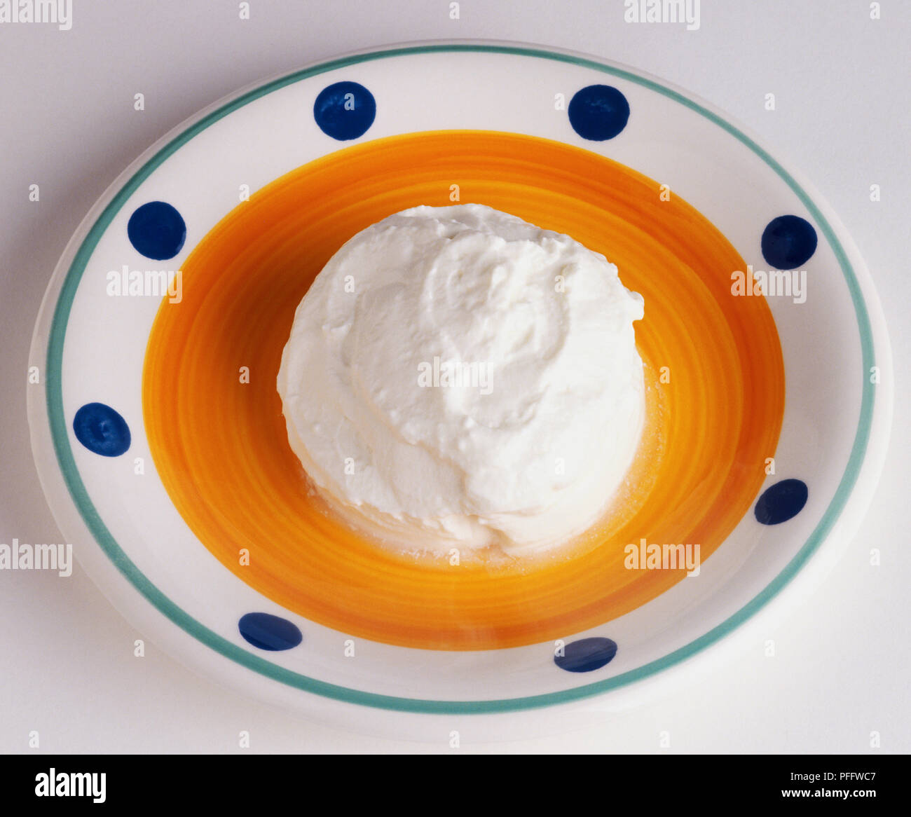 Gemusterte Gericht mit einer Kugel dicker Joghurt in der Mitte. Stockfoto