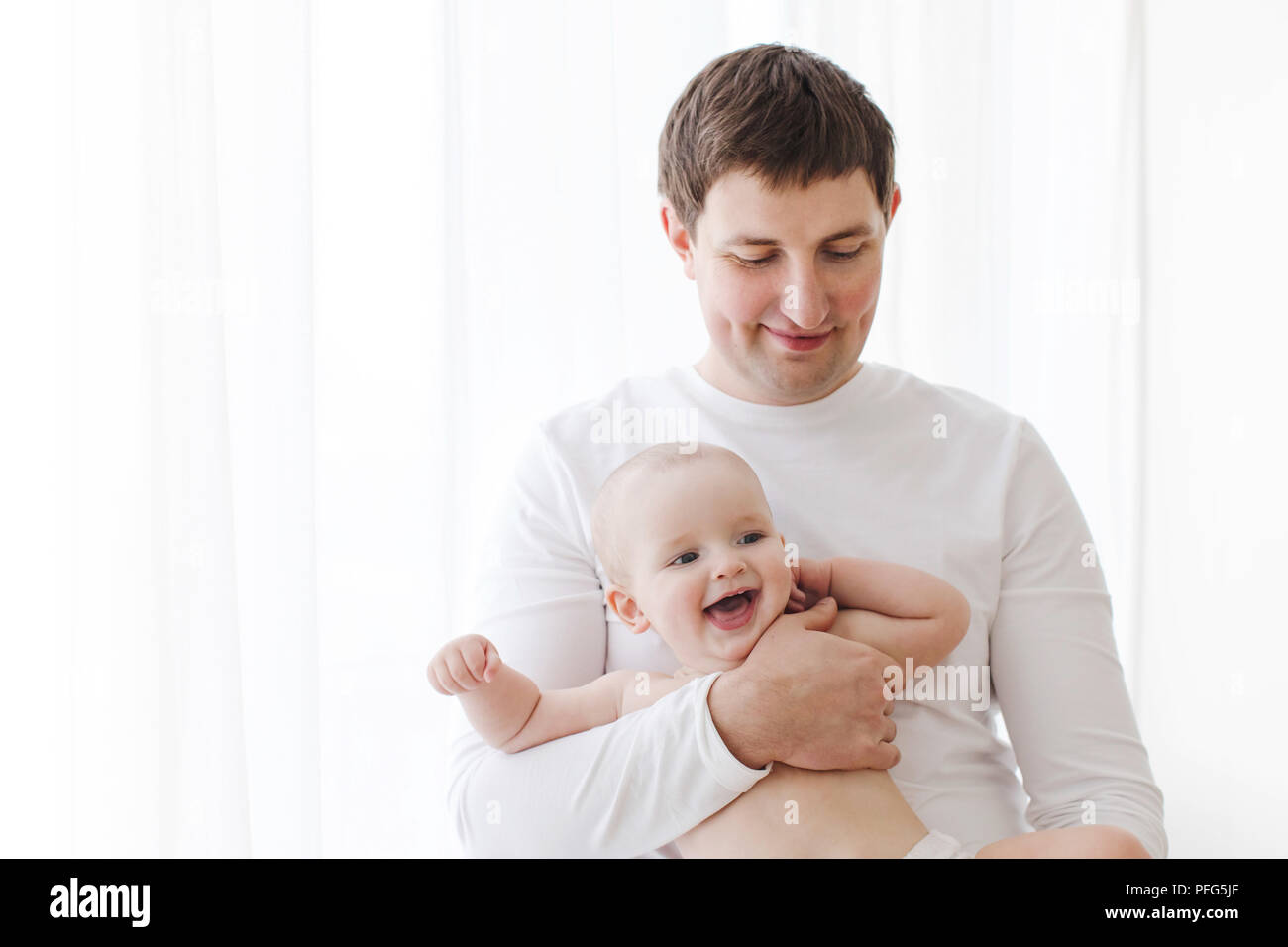 Vater Holding fröhliches Baby Stockfoto